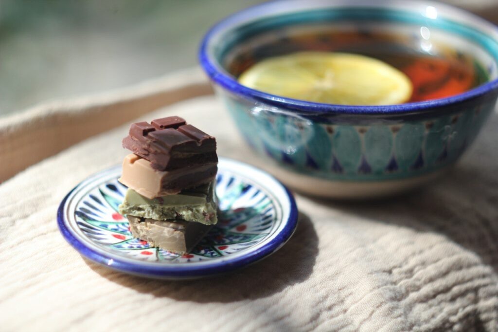 Сверху вниз: горький шоколад Masala, белый шоколад с ройбосом и орехами, белый шоколад с Тегуаньнинью и какао-крупкой и белый шоколад с черным чаем и лимоном. А еще риштанская керамика, кенийский чай и узбекский лимон.