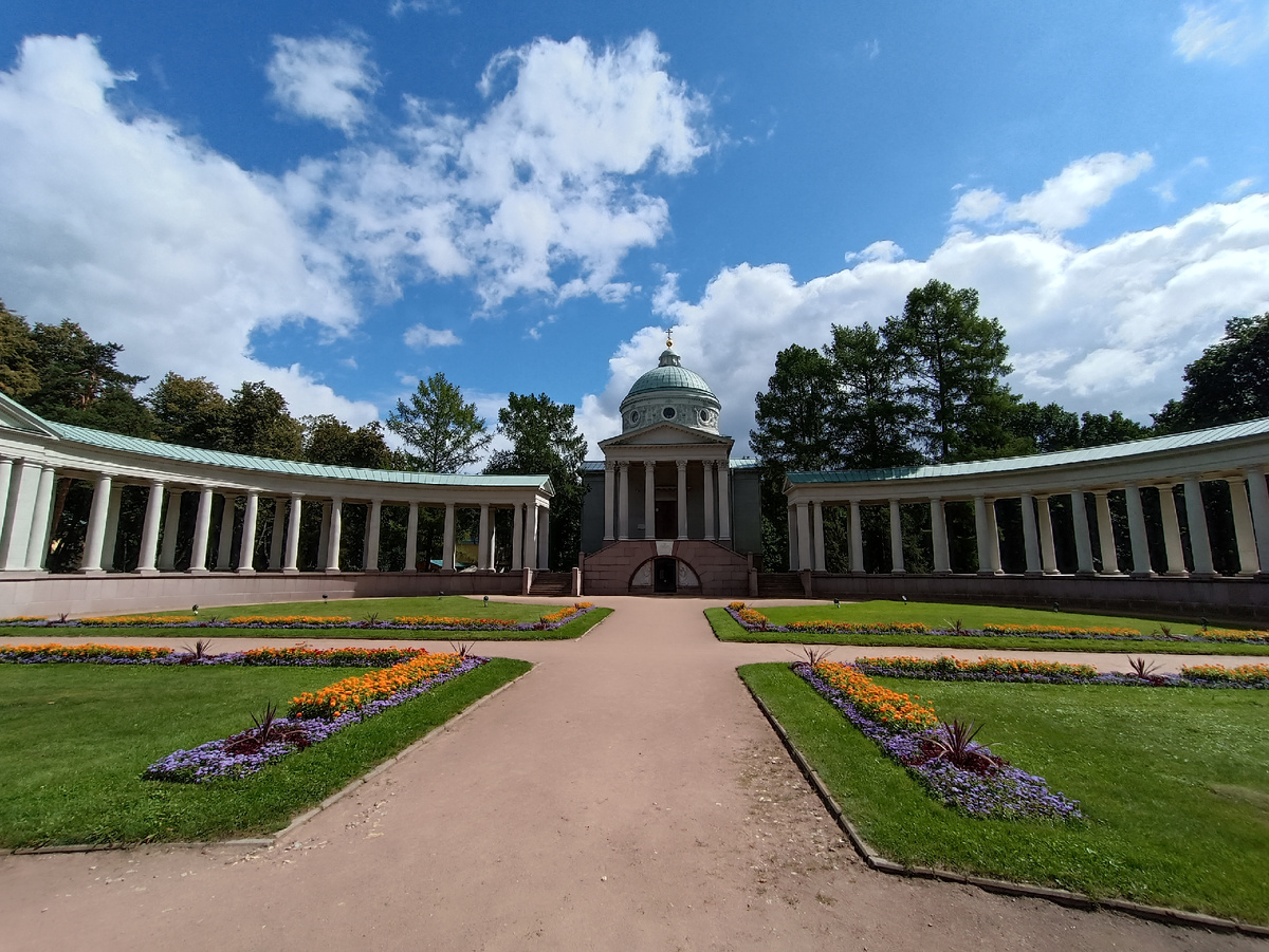 Это Колоннада.В конце XIX – начале ХХ века последняя владелица Архангельского княгиня Зинаида Николаевна Юсупова (1861–1939) часто приезжала в усадьбу вместе с супругом графом Феликсом Феликсовичем Сумароковым-Эльстоном – старшим (1856–1928), после женитьбы также получившим право на титул князя Юсупова, и сыновьями Николаем (1883–1908) и Феликсом-младшим (1887–1967).Рядом с храмом Архангела Михаила погребена сестра Зинаиды Николаевны Татьяна, умершая в 1888 году. Когда в 1908 году на дуэли погиб старший сын княгини Зинаиды Юсуповой Николай, его похоронили там же. В память об этом трагическом событии Юсуповы решили воздвигнуть в Архангельском новый храм-усыпальницу во имя святителя Николая Чудотворца. Замысел не был полностью воплощен, однако это величественное сооружение, известное также под названием «Колоннада», стало важной и неотъемлемой частью архитектурного ансамбля усадьбы.Для создания храма-усыпальницы был приглашен видный русский архитектор Р.И. Клейн (1858–1924). Мастер исторических стилей, Клейн в своих московских постройках виртуозно использовал архитектурные образы далеких эпох. Так, например, универсальный магазин Мюра и Мерилиза (ныне – здание ЦУМа) был им решен в ключе неоготики, Средние торговые ряды на Красной площади – в русском стиле, Бородинский мост – в духе неоклассицизма, основанного на мотивах ампира. Неоклассицизм с отзвуками античного искусства особенно выразительно применен архитектором в проекте Музея изящных искусств (ныне – ГМИИ им. А.С. Пушкина).