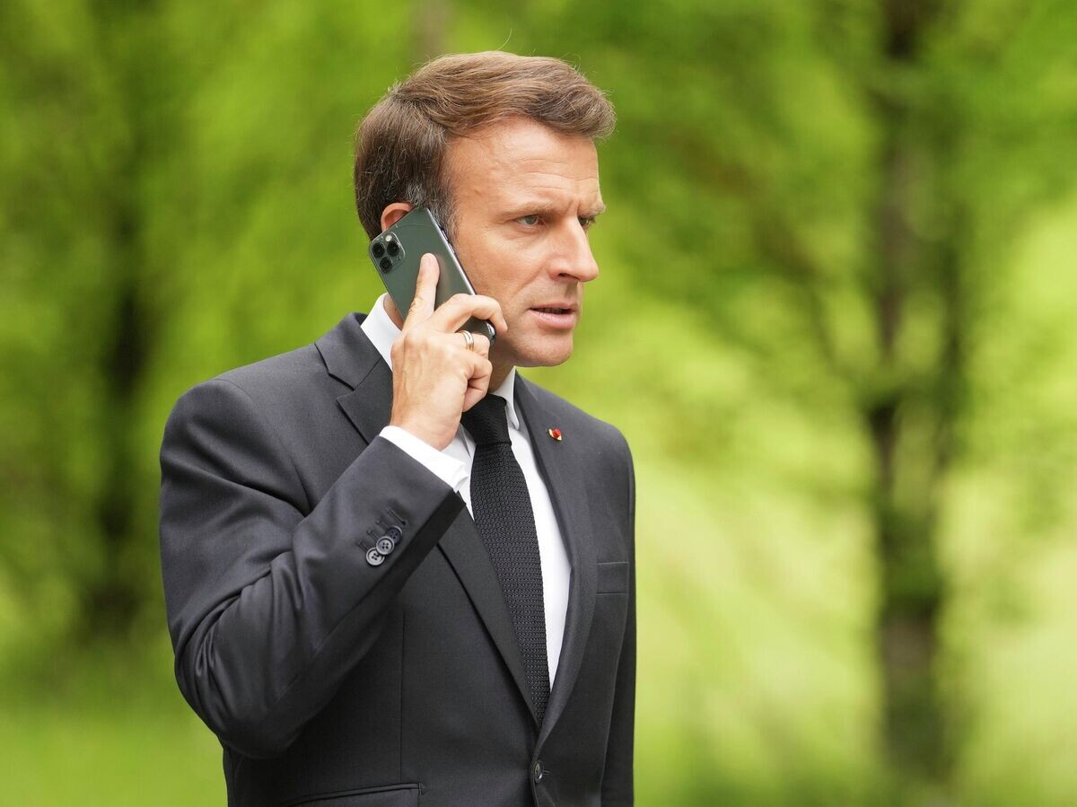    Президент Франции Эммануэль Макрон говорит по телефону на саммите G7 в замке Эльмау© AP Photo / Markus Schreiber