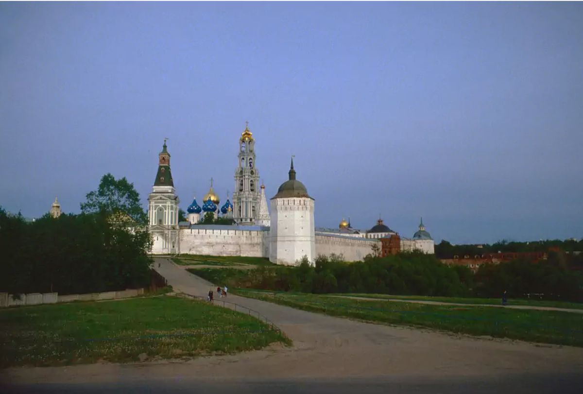Вид на Троице-Сергиеву Лавру с северо-запада. Справа налево - Каличья башня, далее купола Успенского собора, колокольня, шатровый верх церкви Зосимы и Сааватия и Плотничья башня. Дорога идёт через мост к воротам Каличьей башни