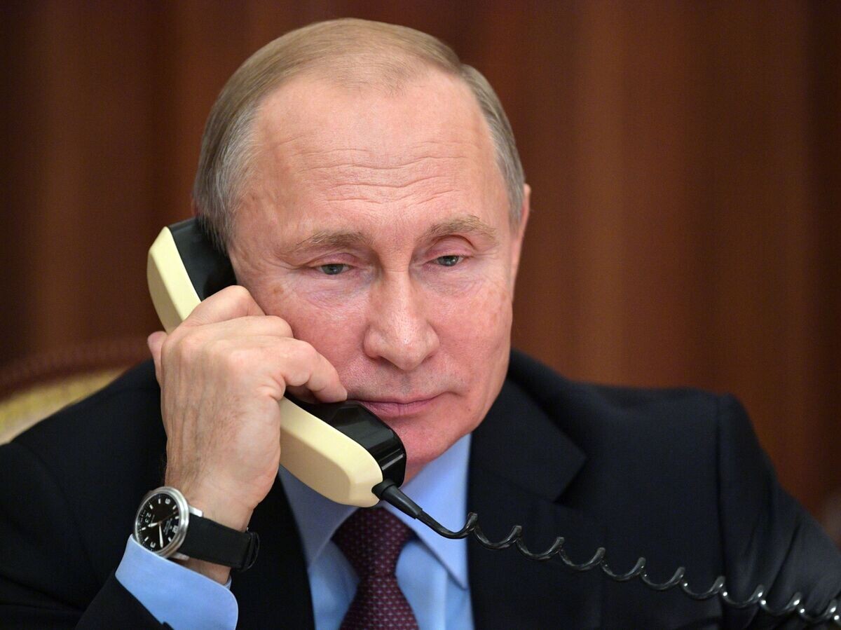     Президент РФ Владимир Путин во время разговора по телефону с одним из участников проекта "Мечтай со мной" Арсланом Каипкуловым. 25 декабря 2018© РИА Новости / Алексей Дружинин