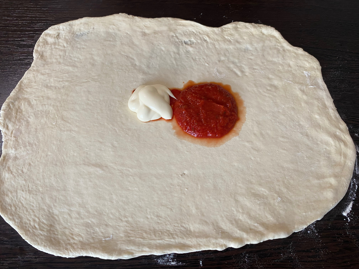 Раскатывает тесто 