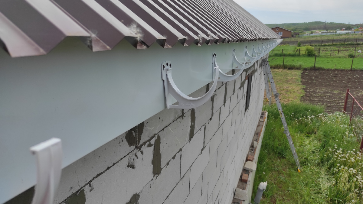 Монтируется крепеж для желоба и сливной трубы