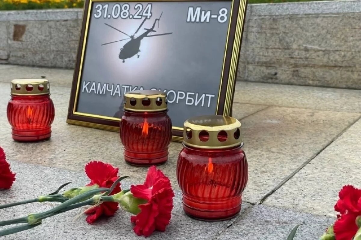    Люди несут цветы к стеле "Город воинской славы".