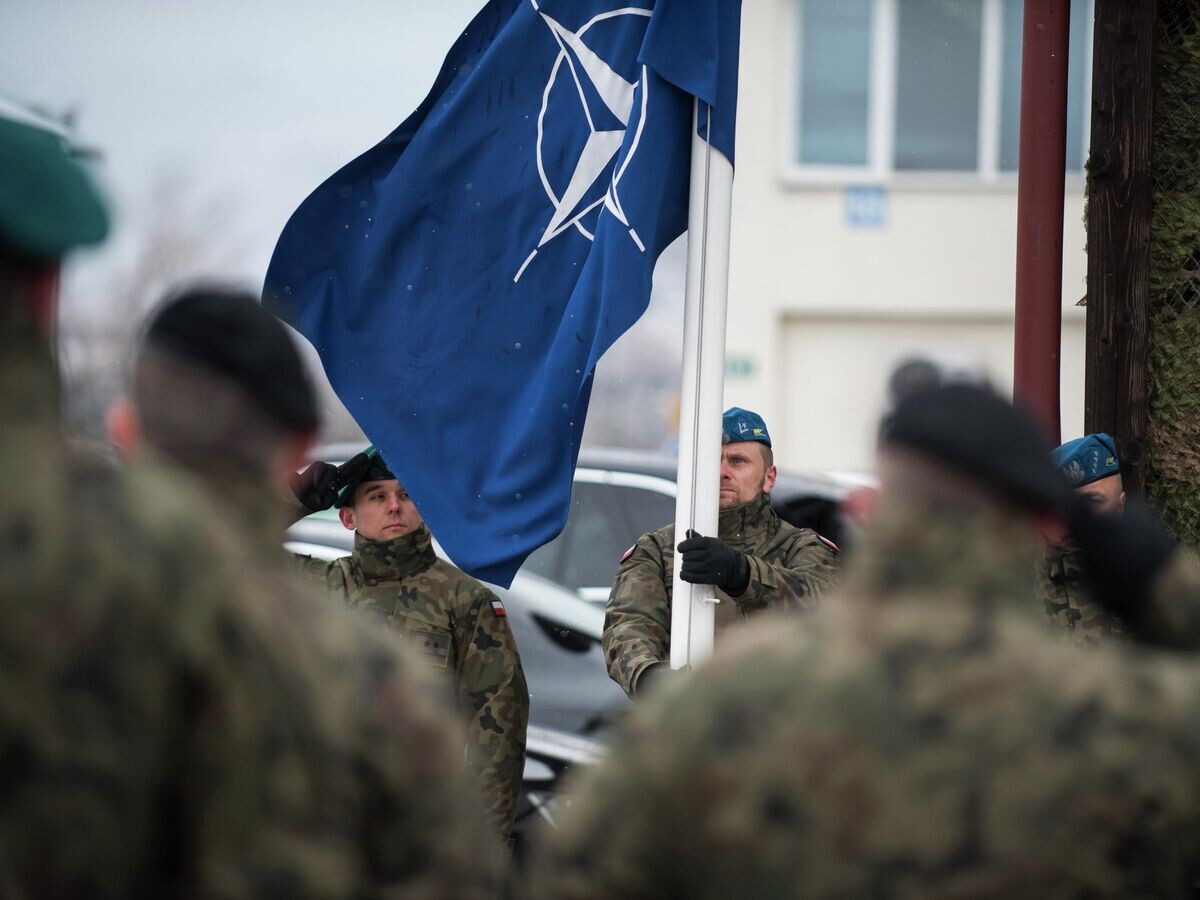    Польские военнослужащие поднимают флаг НАТО во время торжественной церемонии празднования 20-летия присоединения Чехии, Венгрии и Польши к блоку © Фото : U.S. Air Force / Tech. Sgt. Clayton Lenhardt
