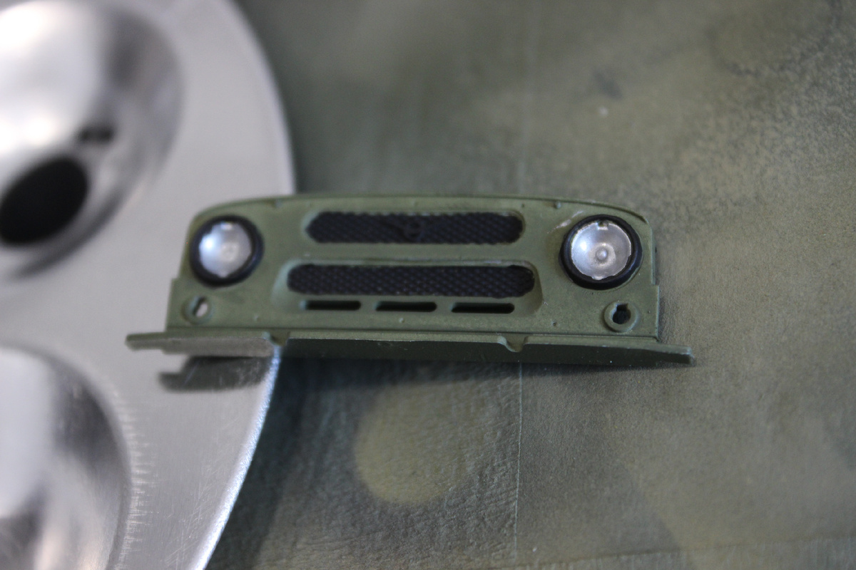 Третий слой "серебрянки" в отражателях дал нужный эффект, но пришлось подождать высыхания. Также выделил решетки радиатора черным и рамки фар.