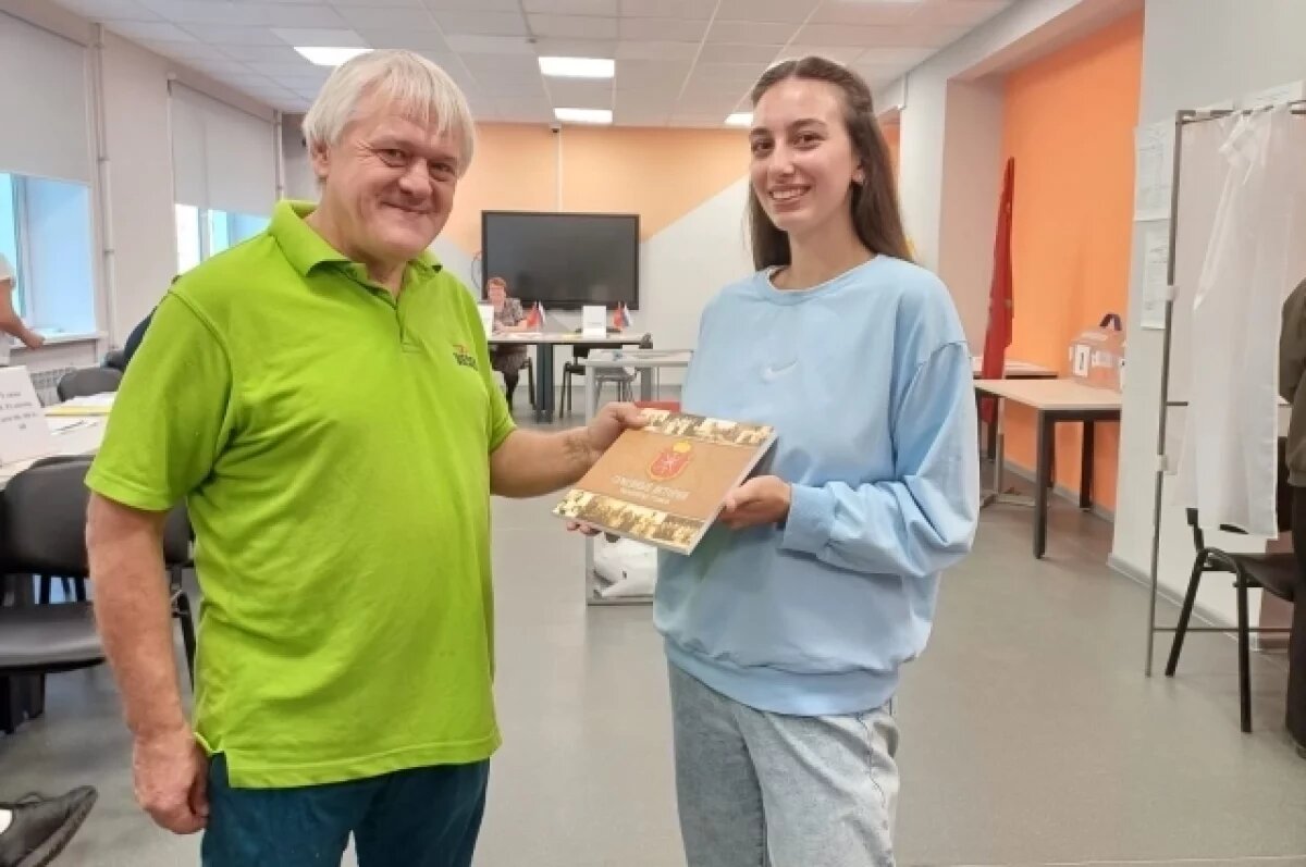    Сергей Гусев вручает книгу впервые проголосовавшей Виктории.