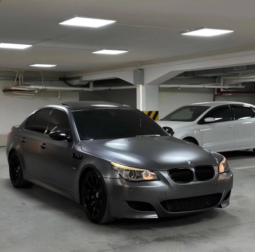 
BMW M5 E60 - это не просто седан, это воплощение спортивной элегантности и бескомпромиссной мощности. Выпущенный в 2005 году, он стал одним из самых культовых автомобилей своего времени, и вот почему:

Дикий нрав под элегантной оболочкой:

* 5,0-литровый V10 с атмосферным впрыском, выдающий 507 л.с. и 520 Нм крутящего момента.
* Разгон до 100 км/ч за 4,7 секунды.
* Максимальная скорость ограничена электроникой на 250 км/ч.

Технологический прорыв:

* 7-ступенчатая роботизированная коробка передач SMG III с двойным сцеплением.
* Система полного привода M xDrive с возможностью отключения заднего дифференциала для захватывающего дрифта.
* Система динамического контроля устойчивости DSC с режимом Sport для более спортивного вождения.
* Электронная подвеска EDC с тремя режимами работы: Comfort, Normal и Sport.

Дизайн, который завораживает:

* Агрессивный и элегантный дизайн с широкими колесными арками, массивным передним бампером и спойлером на крышке багажника.
* Роскошный интерьер с высококачественными материалами, спортивными сиденьями и эргономичным рулем.
* Многофункциональный руль с кнопками управления системами автомобиля.
* Цифровая приборная панель с информативным дисплеем.

Преимущества:

* Мощный и эмоциональный V10 двигатель.
* Отличная управляемость и динамика.
* Роскошный и комфортабельный салон.
* Уникальный и спортивный дизайн.

Недостатки:

* Роботизированная коробка передач SMG III была известна своей несовершенной работой.
* Высокий расход топлива.
* Не подходит для всех типов дорог.

BMW M5 E60 - это автомобиль для истинных ценителей драйва и спортивных автомобилей. Он сочетает в себе элегантный дизайн, мощный двигатель и высокотехнологичную начинку, что делает его настоящим шедевром.