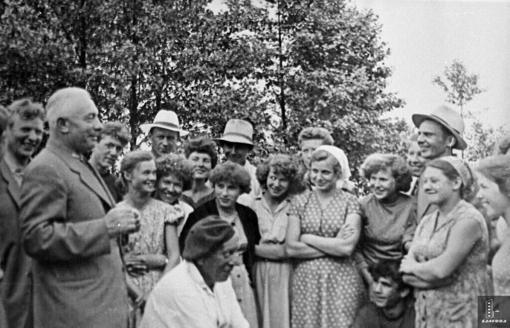 Белорусский писатель Михаил (Мiхась) Лыньков среди своих юных почитателей на берегу озера Нарочь, ЦГАМЛИ БССР, Минская область, лето 1959 г. Некоторые родители этих молодых книгочеев так и остались неграмотны, часть их пап и мам учились грамоте в солидном возрасте, например, в вечерних школах, в то время как их дети, несмотря на недавно отбушевавшую Великую Отечественную войну, уже с ранних лет знакомы с миром отечественной и зарубежной книги. И им посчастливилось увидеть тех, кто его создавал — белорусских национальных писателей, прижизненных классиков и знаменитостей.