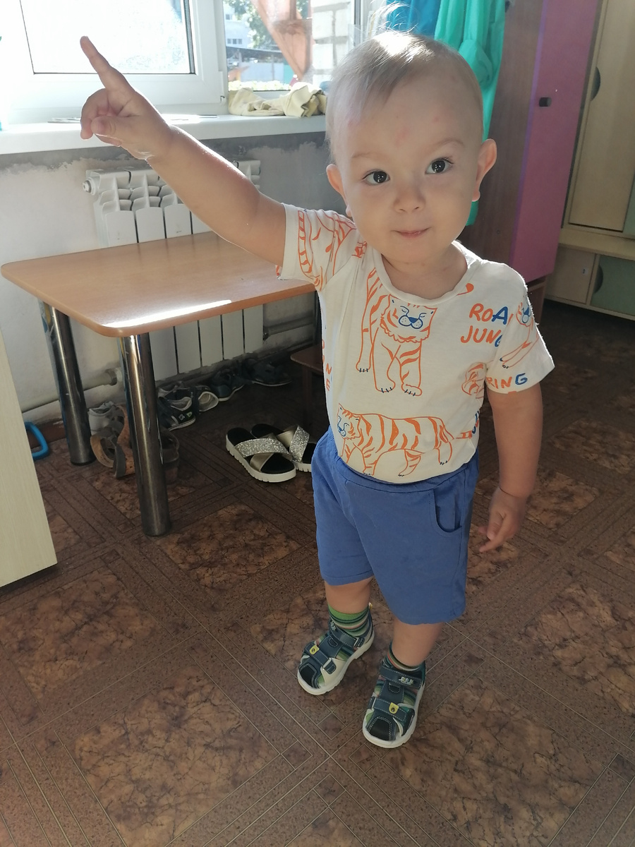 Первый день в детском саду, Саша показывает на дверь группы. В предвкушении, что же там будет! 