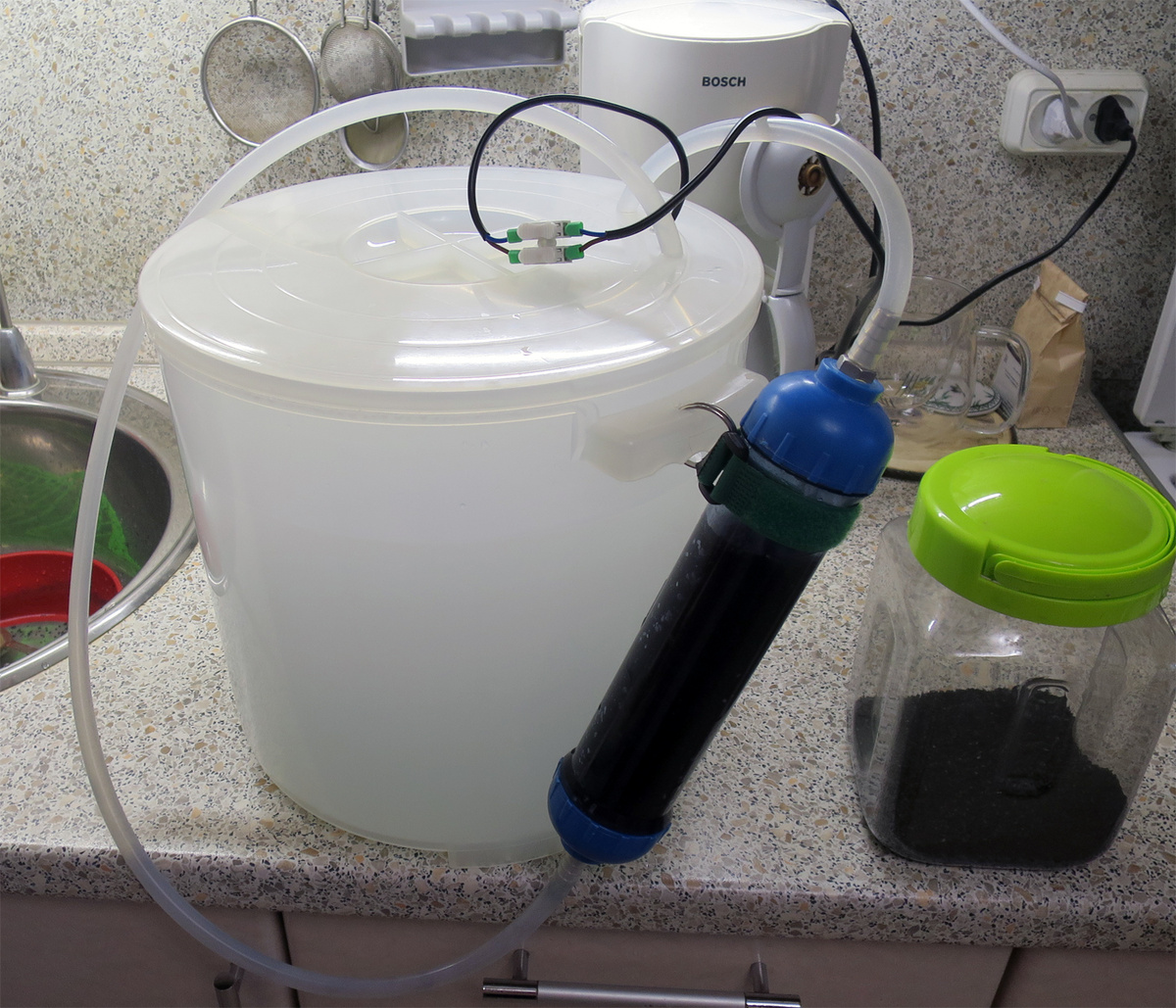 Разбавленный самогон (со дна емкости) проходит через активированный уголь "по кругу" (выливается на поверхность, трубка для слива вставлена примерно на 1-2 см)...