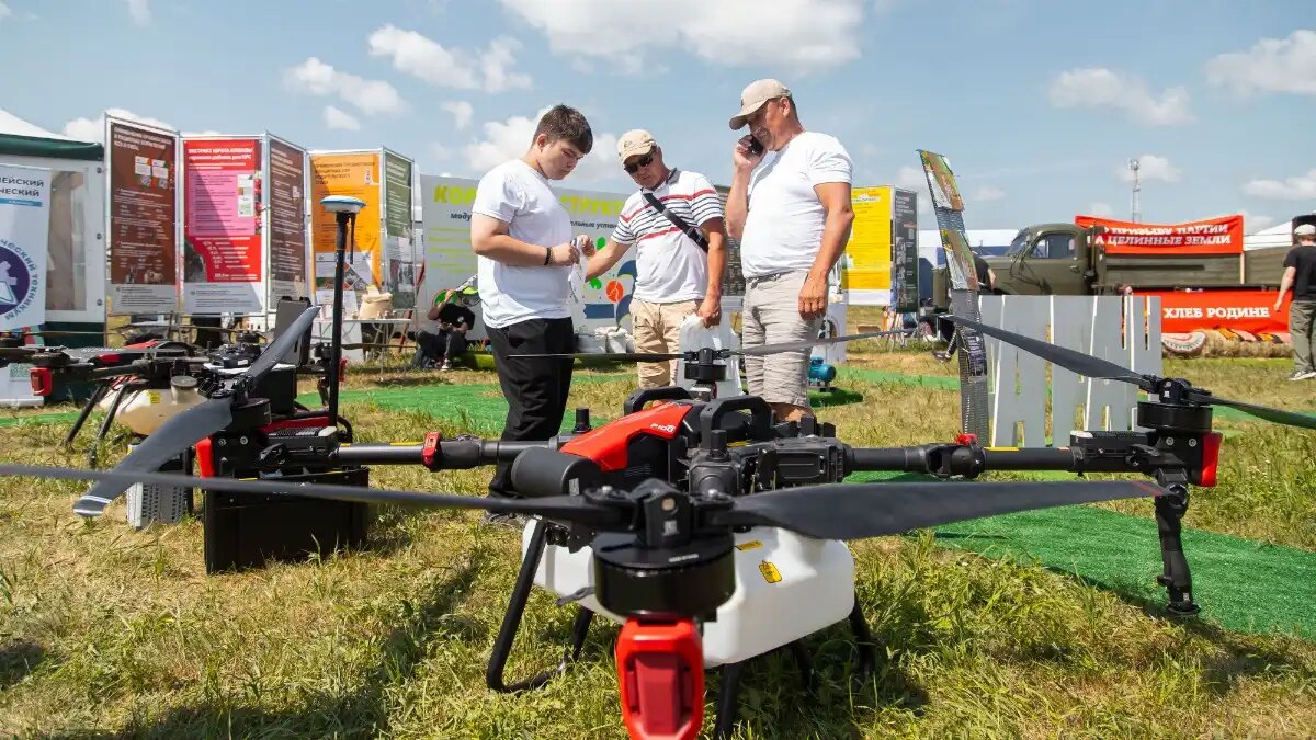 Фото:пресс-служба Алтайского ГАУ преПодаватели Лётной школы АГАУ Владимир Чернышков и Алексей Ковалев и руководитель томской компании Смотрим с неба Евгений Макаров знакомят посетителей выставки с устройством современных беспилотников