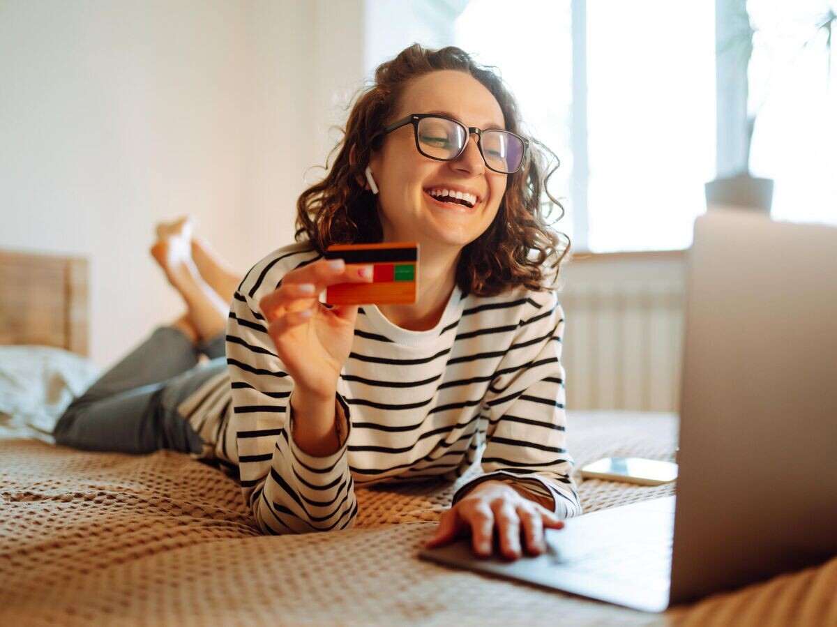    Девушка с ноутбуком и банковской картой© iStock.com / Maksym Belchenko