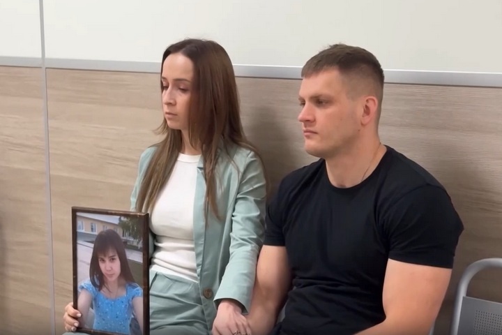 Сестра погибшей Сабрины держит в руках ее портрет. Кадр из здания суда