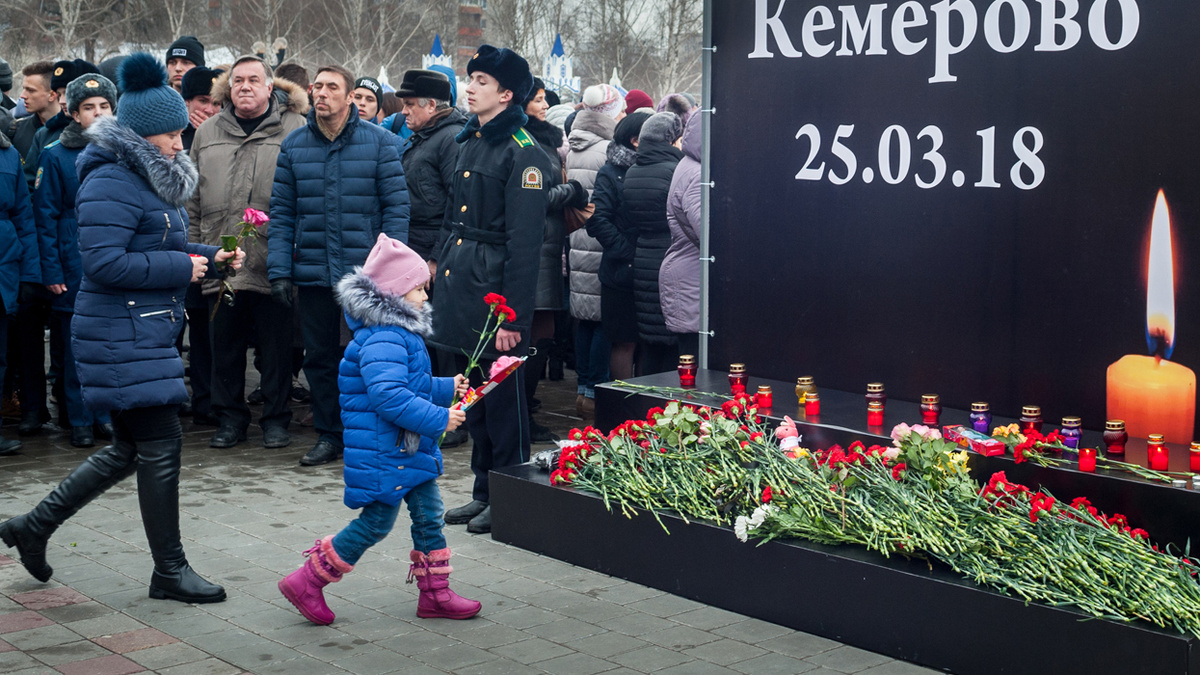 Люди несут цветы в память о погибших в ТЦ "Зимняя Вишня".