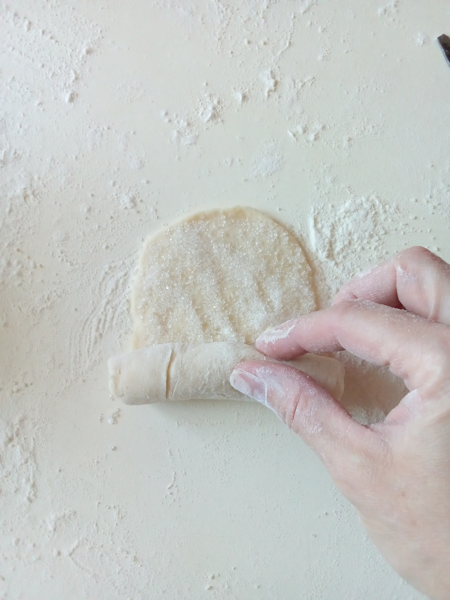 Раскатать небольшой овальчик, посыпать сахаром и скрутить