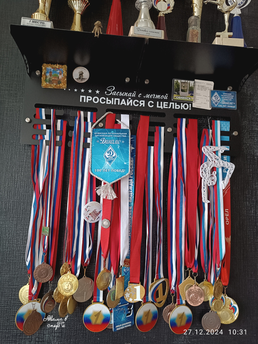 Медальница дочки. Там и значки за разряды и сувенирные значки, и даже билет на самолёт в Калининград и пузырёчек с собственноручно собранными янтариками.