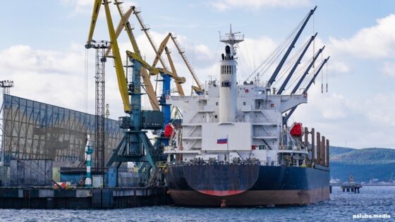 «Медиапалуба» выражает благодарность пресс-службе «Портового альянса» за организацию посещения ММТП и возможность ознакомиться с работой предприятияВ последние годы Мурманский морской торговый порт (ММТП) из пункта для перевалки грузов приобрел статус стратегически важного предприятия с прямым выходом для России в Мировой океан. Одновременно он стал отправной точкой для судов, идущих по кратчайшему морскому маршруту с Запада на Восток.Но как известно, перемены эти были вызваны не самыми позитивными событиями. Санкции сказались на грузовой базе, направлениях доставки и многолетнем пуле клиентов. Перестраиваться пришлось на ходу и сегодня портовики продолжают адаптироваться под рынок — рассматривают новые грузы, технологии перевалки и расширяют мощности.«Медиапалуба» посетила предприятие и подготовила большой обзор об устройстве и возможностях мурманского порта в новых реалиях.СодержаниеУстройство и мощности
Для обработки грузов в порту обустроено 15 причалов. Один из основных, причал №2, ввели в эксплуатацию в этом году после масштабной реконструкции. В результате работ проектная глубина причальной акватории увеличилась до 12,1 метров, а причальную линию продлили до 284 метров. Это позволило начать здесь обработку судов типоразмера Panamax и увеличить общую мощность причала до 5 млн тонн. Следующий шаг — расширение его технологических возможностей под обработку судов Capesize. Сейчас в порту функционирует три таких причала.
Мы идем по пути увеличения тоннажности флота. На данный момент ведется большая научная работа по этому проекту, она на стадии завершения. Размерения Capesize — это максимальные габариты сухогрузов, которые заходят в российские порты на данный момент. В этом году число таких судозаходов в нашем порту значительно возрастает. — Заместитель директора ММТП по производству Андрей Ризниченко.📷
📷
Еще три причала на территории порта занимает Мурманский балкерный терминал (МБТ), работающий с минеральными удобрениями (калийными, фосфорными и азотными) и железорудным концентратом.Для минеральных удобрений характерна высокая гигроскопичность — свойство впитывать влагу, которое негативно влияет на качество продукции. Чтобы исключить это воздействие, выгрузку и погрузку производят в закрытом виде: груз доставляют в вагонах, отправляют на станции разгрузки, а оттуда по закрытым конвейерным линиям либо на склад, либо сразу в трюм. Для хранения перегружаемых материалов организовано три купольных склада вместимостью около 20 тысяч тонн.📷
📷
Грузооборот терминала по итогам прошлого года составил почти 5 миллионов тонн (при проектной мощности в 8 млн тонн), на такие же цифры планируют выйти и в этом году. Больша́я часть продукции отправляется на экспорт: основные получатели железорудной продукции представлены странами Азии, а удобрения идут в Латинскую Америку.Недавно на терминале запустили перевалку железорудного окатыша — сырья для изготовления стали и различных металлов:
Для нас это новый вид груза. Месяц назад мы отработали судовую партию, грузовладельца все устроило. Надеемся, что это направление будет функционировать на регулярной основе. — Исполнительный директор МБТ Евгений Гуляев.📷
📷
📷
В ближайшее время на МБТ запустят проект по наращиванию внутренней эффективности:
У нас есть большая программа по модернизации комплекса минеральных удобрений, в которую входит внедрение технологий для ускорения выгрузки вагонов и погрузки на судно. Мы заключили договор с подрядчиком, который будет выполнять эти работы в рамках 2024 года. — Исполнительный директор МБТ Евгений Гуляев.Техника и кадры
В порту работает 38 портальных кранов, 16 кранов-манипуляторов, 50 погрузочных машин и более 149 единиц прочей техники. Парк планомерно обновляется и осовременивается, например, на смену массивным портальным кранам приходят гидравлические — мобильные и маневренные.Одна из специфических потребностей северных портов — работа с грузом, который при перевозке подвергается замерзанию. С этой проблемой борются манипуляторы c грейферами, оснащенными мощными челюстями.📷
📷
В этом году общий объем инвестиций в развитие порта составит более 1,15 миллиардов рублей. Сюда входит и закупка оборудования, и уже завершенная реконструкция причала. В руководстве не исключают дальнейших проектов по модернизации мощностей, но они будут зависеть исключительно от формирования новых грузопотоков и потребностей для работы с ними.📷    Фото: Медиапалуба
Острого дефицита кадров предприятие не испытывает. Ощутимая нехватка наблюдается только в сегменте рабочих профессий: в порту всегда требуются электромонтеры, слесари, механики и др.
У нас стабильное предприятие и люди здесь работают по много лет. Мы обеспечиваем «приличные» зарплаты, у нас много разных мер поддержки коллектива. Поэтому текучка довольно низкая и она не сказывается на нашей работоспособности. — Исполнительный директор ММТП Павел Олейник.📷    Павел Олейник / Фото: Медиапалуба
Новая база
Главный «хлеб» предприятия — это уголь, который составляет более 80% от общего объема обрабатываемых грузов. Но как отмечают эксперты, традиционная для мурманского порта номенклатура со временем перестает быть рентабельной. Причины кроются в снижении цен на энергетический уголь на мировом рынке и высоких транспортных расходах на доставку. Одновременно в спину дышат конкуренты — строящийся по соседству порт Лавна и субсидируемый, хоть и перегруженный Восточный полигон.📷    Фото: Медиапалуба
Мурманский морской порт считается универсальным. Это значит, что его мощности, техника и персонал рассчитаны на работу с любыми типами грузов — достойное преимущество предприятия в условиях стремительно меняющейся экономики и переориентирования грузовой базы и логистики в целом.
В настоящее время мы работаем не только с углем, в последние два года у нас фиксируется значительный объем инертных грузов: в прошлом году 1,3 млн тонн, в этом году ожидается 500 000 тонн. Объем, как видите, нестабильный в цифрах, но он есть. — Исполнительный директор ММТП Павел Олейник.Также сейчас на рассмотрении перевалка селитры в биг бэгах, с которой на фоне атаки беспилотников перестали работать в порту Санкт-Петербурга. Перспективный объем по обработке — до 1,3 млн тонн в год. Сейчас в порту разрабатываются и адаптируются технологии хранения и обработки в соответствии с требованиями безопасности. На МБТ уже зазгрузили два судна с первыми партиями селитры по системе «вагон – трюм».📷    Андрей Ризниченко / Фото: Медиапалуба
Еще одно перспективное направление — контейнеры:
Есть заинтересованные китайские компании. Они уже возят контейнеры через Архангельск, но их не устраивает скорость обработки. Плюс — Белое море замерзает. Дооснащение в порту при этом не потребуется, все мощности для работы с этими грузами в порту есть. Мы много работали с генеральными грузами, все эти вещи нам знакомы. Тут вопрос только размещения и хранения. — Заместитель директора ММТП по производству Андрей Ризниченко.Из-за нехватки платформ на железной дороге рассматривается вариант погрузки контейнеров в полувагонах. Пока в планах тестовый рейс, который может состояться уже в этом году. Помимо экономических факторов, проект будет зависеть в том числе от погоды и ледовых условий на маршруте.
На сегодняшний день мощности по углю у нас недозагружены и мы привлекаем другие номенклатуры. Работаем с новыми уже сейчас, но насколько они стабильны и долгосрочны, будет понятно со временем.Если, скажем, железнодорожные тарифы изменятся и нам будет выгоднее работать с металлами из Череповца или Липецка, мы будем сотрудничать с ними. Если контейнеры начнут активно отправлять из Китая по Северному морскому пути, мы будем с этим работать. В общем, будем использовать наши возможности при соответствующих экономических условиях, так как способны быстро переключаться с одного грузопотока на другой. — Исполнительный директор ММТП Павел Олейник.Северный морской порт
Мурманск считается опорным портом российской Арктики и стартовой точкой Северного морского пути по направлению с Запада. В этом году почти весь грузооборот предприятия по СМП обеспечивается за счет навалочных грузов. В прошлом был большой поток по генеральным грузам за счет проектов по строительству транспортной инфраструктуры, предприятий по переработке и добыче полезных ископаемых в Арктике. Сейчас из-за санкций многие из этих проектов замедлились, соответственно, уменьшились и перевозки материалов для их реализации. В итоге до конца года в ММТП надеются достичь показателей в 600 тысяч тонн навалочных грузов против миллиона, переваленного в прошлом году.📷    Фото: Медиапалуба
Грузы по арктической программе обрабатываются на причале №15. В рамках Северного завоза здесь идет обработка щебня.
За этот год из порта было отправлено шесть судов Capesize, которые уйдут по Севморпути. По сравнению с общим грузопотоком доля арктических грузов пока не так велика, но она активно растет: в прошлом году на СМП ушло около одного миллиона тонн из 17. В 2024 соотношение сохранится. Мы заинтересованы в росте этого грузопотока и будем участвовать в нем при любой возможности. Но нужно понимать, что многое здесь зависит от погоды и от других факторов, которые мы контролировать не можем. — Исполнительный директор ММТП Павел Олейник.Море стопорят железные дороги
В ММТП при текущих мощностях можно перерабатывать до 21 миллиона тонн в год. В прошлом году эти показатели достигли почти 18 млн тонн, в 2024 рассчитывают на 15. Достичь максимальных показателей мешает не только недостаточный грузопоток, но и перегруз смежного транспорта — железной дороги.
Мурманский транспортный узел имеет профицит перевалочных мощностей над провозной способностью железной дороги. Сегодня ЖД — это узкое горлышко в логистике. За эти мощности терминалы между собой конкурируют. — Исполнительный директор МБТ Евгений Гуляев.📷    Фото: Медиапалуба
Сейчас в России практически во всех портах наблюдается профицит мощностей по сравнению с пропускной способностью железных дорог. Особенно остро эта проблема проявилась в этом году на Дальнем Востоке. Похожие трудности существуют в Усть-Луге, а также периодически возникают в Сибири и в Мурманске. Сюда относится и пропускная способность Октябрьской железной дороги, по которой грузы поступают в Мурманск; и инфраструктура железнодорожной станции Мурманск, которая на сегодняшний день загружена почти на 95%.
Поживем — увидим. РЖД предпринимает определенные шаги, но вопрос заключается в том, как они оценивают ситуацию и какие планы имеют по ее решению. Губернатор говорил о том, что сейчас они будут реализовывать программу по увеличению пропускной способностей транспортных узлов. Мы надеемся, что все это будет реализовано. — Исполнительный директор ММТП Павел Олейник.Пыльная работа
Мурманский порт находится в черте города и здесь перерабатывают обильно пылящийся груз. Дабы избежать разногласий с горожанами, портовики активно вкладываются в различные технологии пылеподавления. За последние несколько лет здесь установили комплексы из пылеветрозащитных экранов, поставили водяные пушки, на пересыпных станциях оборудовали системы магнитной очистки угля.📷
📷
На этом программа по минимизации воздействия от перевалки угольных и прочих грузов не заканчивается. Продолжается закупка мобильных установок, которые позволят контролировать распространение пыли в районе складов и на других территориях порта. В этом году была запущена разработка совместно с Институтом математического моделирования РАН по внедрению новых технологий по снижению угольного пылеобразования.
Вместе с коллегами-учеными мы расчитали довольно сложную математическую модель, которая показала нам эффективность текущих и потенциальных мер. Параллельно мы нашли способы повысить эту эффективность за счет дополнительных действий, которые сейчас реализуем. Это совокупный комплекс действий, показатели которого зависят от ветровой нагрузки, погодных условий, парения, конфигурации складов и многих других факторов. — Исполнительный директор ММТП Павел Олейник.