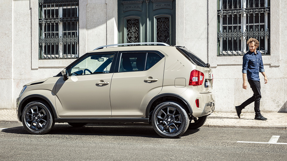 Suzuki Ignis припаркован на оживленной улице, демонстрируя свои компактные габариты и легкость парковки.