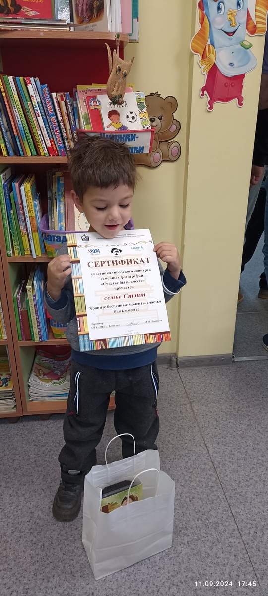 Довольный ребенок с сертификатом и подарком