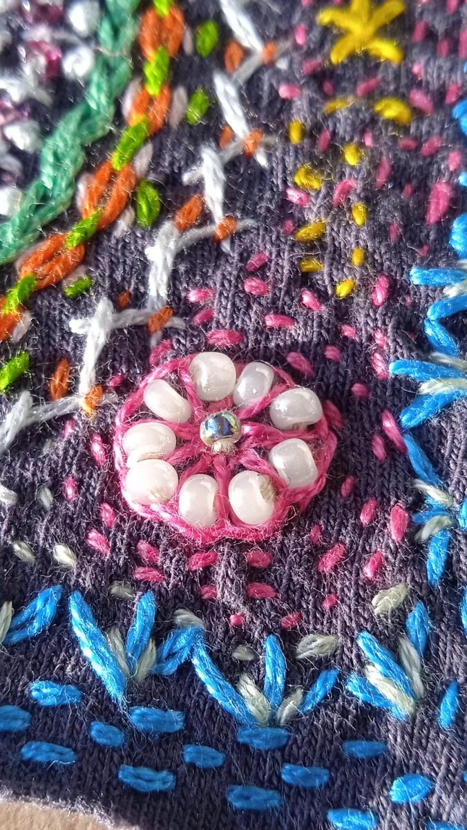 Добавила бисер на розовый цветочек и стежки светло-зелёной нитью по всему периметру вышивки. 