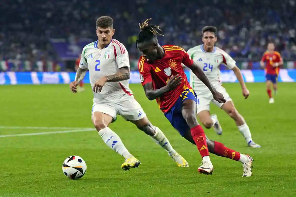 Нико Уильямс пытается уйти на скорости от игрока сборной Италии