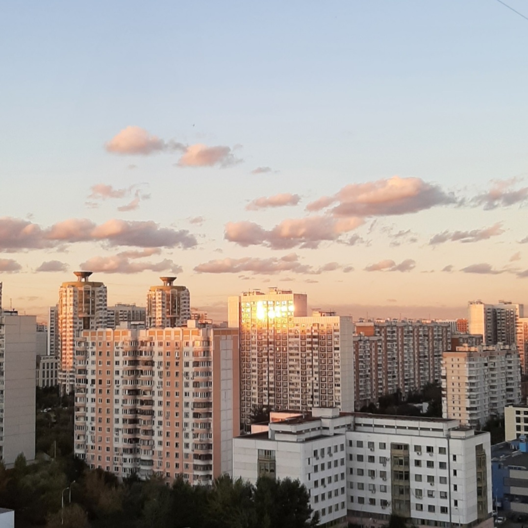 Отблеск заката в окнах многоэтажек. Вид из окна кухни.