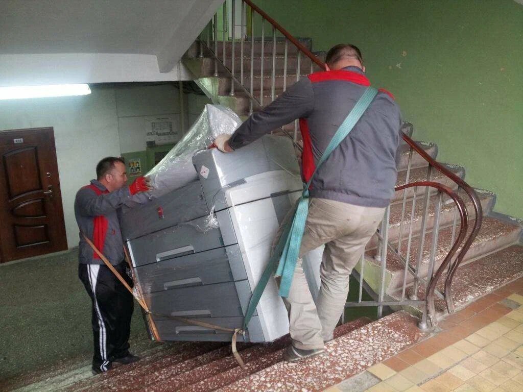 Такелажники спускают груз по лестнице