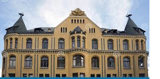 Дом с чёрными котами (Kaku nams) - одна из визитных карточек Риги, столицы Латвии. Эта популярная достопримечательность и одна из наиболее легендарных построек города располагается в центральной части Старого города Риги. Но, чтобы понять, почему он так знаменит, следует знать его историю, связанную с ним легенду, а также несколько других интересных фактов. Здание было построено в 1909 году по проекту знаменитого Фридриха Шеффеля (латышский архитектор и инженер немецкого происхождения). Выполнено в стиле позднего рационального модерна.
Всего на башнях симметрично установлены скульптуры двух чёрных котов. Коты расположены справа и слева и как будто бы смотрят на пересечения улицы Мейстару с улицами Маза Смилшу (Малая Песчаная) и Зиргу (Лошадиная). Посередине строения установлена скульптура орла с распахнутыми крыльями — это символический элемент, который олицетворяет бескомпромиссную борьбу всего хорошего со всем плохим до победного финала. Вход в дом обрамляет цветочный декор, также весьма типичный элемент для стиля модерна.
Черные коты на Доме имеют глубокое символическое значение для рижан, олицетворяя их историю, традиции, культуру и гордость за уникальность родного города.
