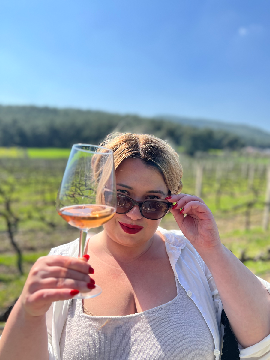 на виноградниках с бокалом розового Мерло винодельни "Кларос"