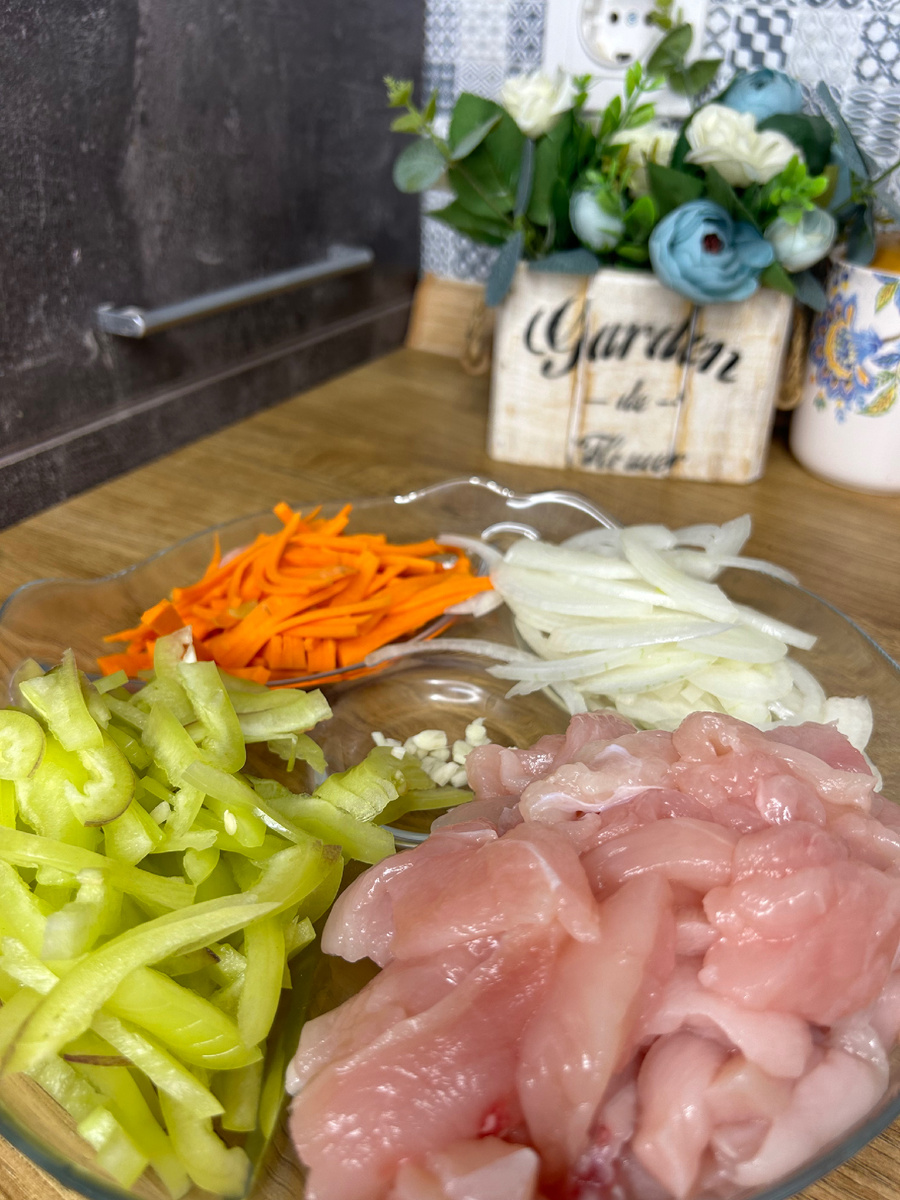 Курицу, перец, лук и морковь нарежьте соломкой. Чеснок мелко порубите