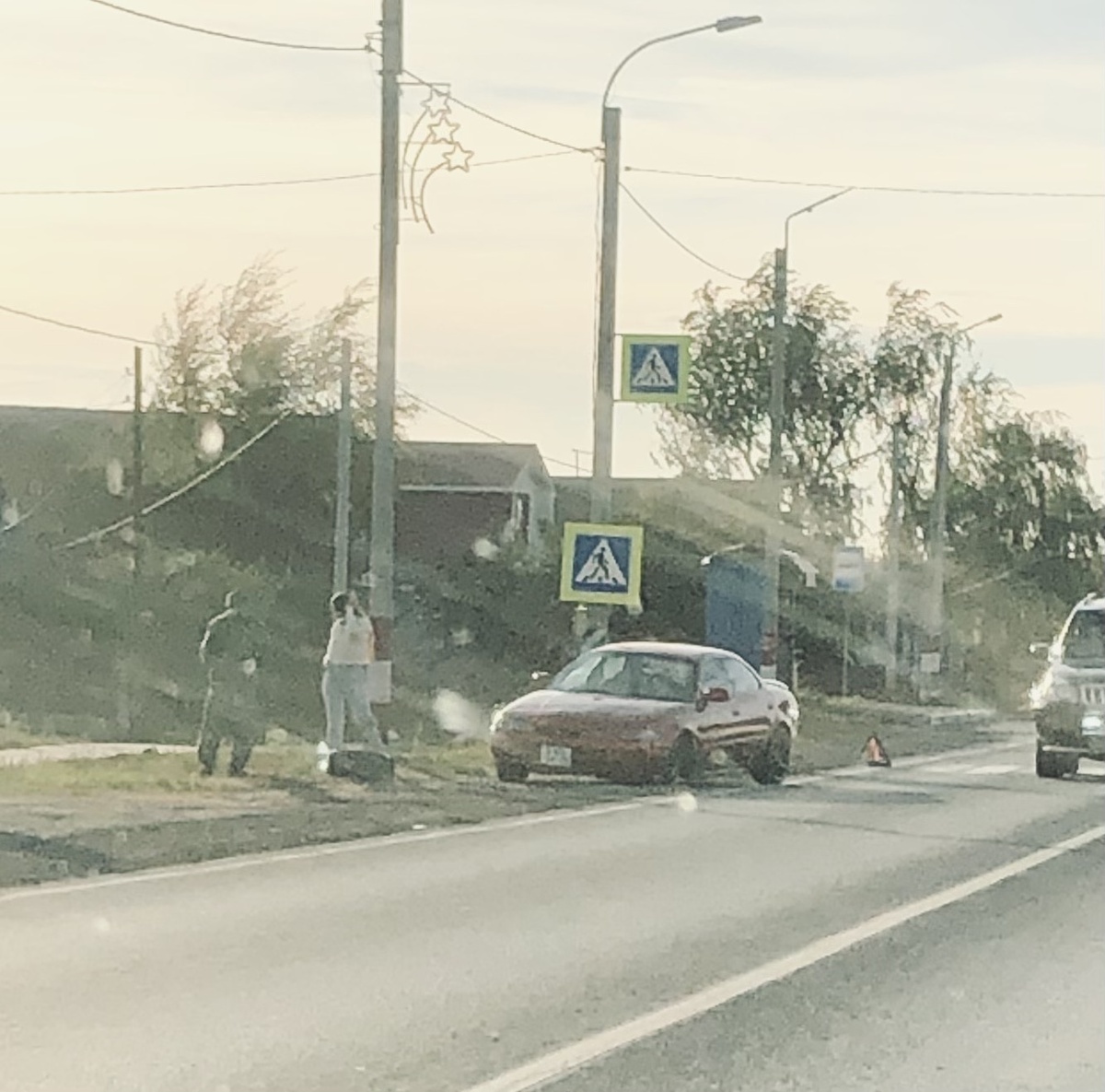 Не знаю, что за марка автомобиля. Переднее левое колесо лежит на обочине.