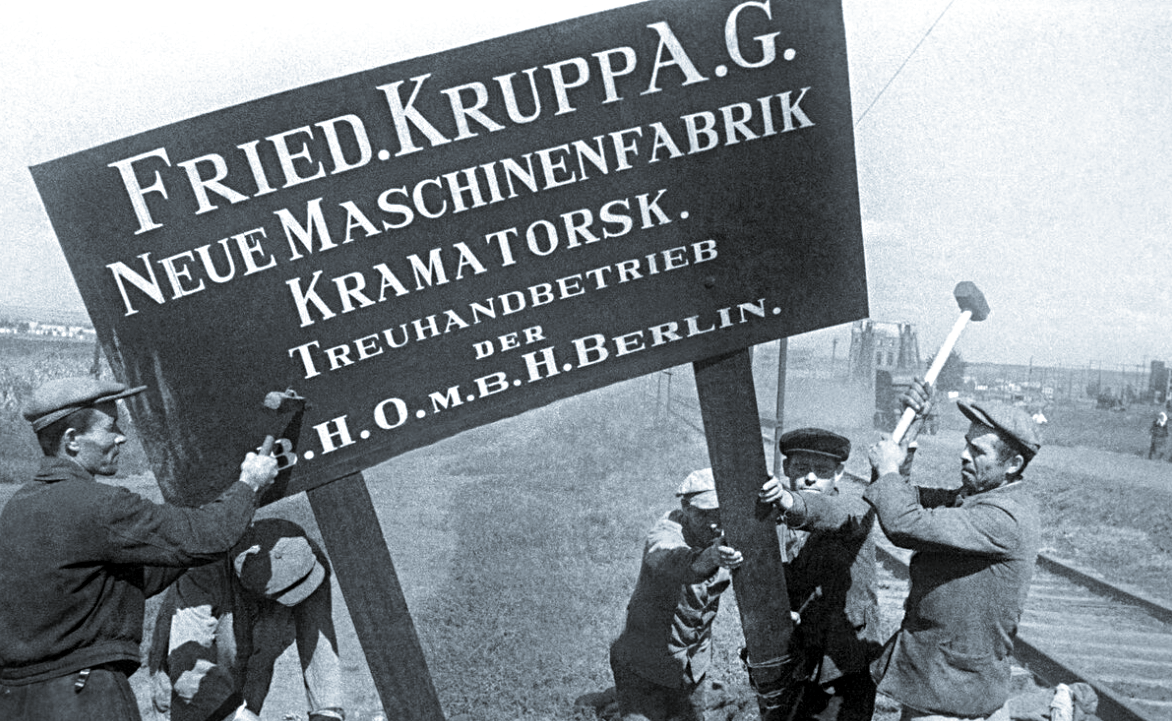 Жители Донбасса демонтируют указатель оккупантов.