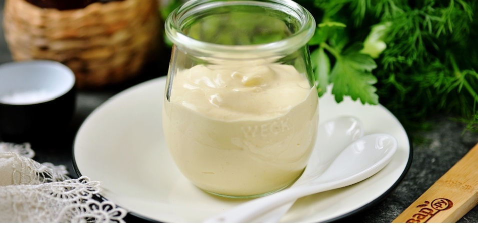 
Что делаете, если майонез, который старательно готовите дома, получается жидковатым? Выбрасываете? Не торопитесь отправлять продукты в мусорку. Мы подскажем, как исправить ситуацию. Дадим практические советы по приготовлению популярного соуса. Чтобы он получился как у лучших поваров.

Какой консистенции должен быть майонез

По густоте майонез похож на сметану. В нём не должно быть комков, пустот, пузырьков воздуха. Консистенция однородная, без расслоения. Если увидели на поверхности лужу жира, не используйте продукт в пищу. Скорее всего, он неправильно хранился и начал портиться.

Как загустить домашний майонез

Если майонез получился жидковатым, не всегда это значит, что нарушена рецептура или технология приготовления. Иногда продуктам необходимо время для стабилизации. Отправьте соус в холодильник на полчаса. Если не помогло, приступаем к реанимации. Есть как минимум четыре способа, чтобы сделать майонез гуще:

*Густота майонеза зависит от его жирности. Добавьте немного растительного масла и снова взбейте массу.
*Добавьте в жидкую смесь один желток и взбейте. Если эмульсия начала густеть, понемногу добавляйте растительное масло. Учтите, что объём готового продукта увеличится. Поэтому соль, горчицу, уксус тоже придётся добавить, чтобы майонез не получился пресным.
*Используйте натуральные загустители. Например, кукурузный крахмал. Разведите ложку крахмала холодной водой, чтобы масса стала похожей на пасту. Заварите её кипятком. Дайте остыть до комнатной температуры. Добавьте к жидкой эмульсии, взбейте.
*Если ни один из способов не помог, придётся начать с начала. Начните взбивать желток с маслом. Как только масса начнёт белеть, постепенно добавляйте неудавшуюся порцию. Продолжайте непрерывно взбивать.

Самый верный способ получить густой майонез — сразу делать все правильно. У домашнего есть особенности в приготовления.

Особенности приготовления соуса в домашних условиях

Для приготовления майонеза в домашних условиях используйте погружной блендер или миксер. Обычный венчик тоже подойдёт. Но процесс взбивания будет более долгим.                                                       Важно соблюдать последовательность взбивания продуктов. Начинайте с желтков. Затем добавьте горчицу и лимонный сок. Его можно заменить винным или столовым уксусом. Взбивайте, пока масса не станет однородной. Примерно 20-30 секунд. Третьим этапом вливайте растительное масло. Малыми порциями. Буквально по столовой ложке каждые 7-10 секунд. Продолжайте при этом непрерывно взбивать. Когда соус станет густым, добавьте специи. Попробуйте на вкус.
Миксер или блендер при взбивании держите неподвижно до тех пор, пока не начнёт образовываться эмульсия. Не перемещайте венчики вверх, вниз, по кругу. Рискуете получить жидкий майонез.

Домашний майонез тем хорош, что получится вашего любимого вкуса. Потому что добавьте в него то, что любите. Куриные яйца можно заменить перепелиными. Вместо обычной горчицы добавить дижонскую. К классическим приправам, соли и перцу, добавить сухой чеснок, свежую зелень. Каждый раз получится новый вкус.


Частые ошибки

Самые умелые хозяйки не застрахованы от ошибок в приготовлении майонеза. Остановимся на самых частых. Не повторяйте их.

Все ингредиенты должны быть комнатной температуры. Подержите их без холодильника не менее 30 минут перед тем, как начать готовить.

Взбивайте майонез на малой или средней скорости. Высокая скорость наполнит соус воздухом, он станет похожим на мусс. Взбивайте непрерывно, не останавливайтесь.

Масло вводите постепенно и маленькими порциями. Взбивайте после каждого добавления 10 секунд. Доверяйте тому, что видите. Если перед вами майонез нужной вам консистенции, а по рецепту надо добавить ещё, не доливайте.


Не взбивайте в широких мисках. Блендер или миксер не смогут захватить весь объём растекшихся продуктов. Лучше использовать узкую высокую посуду. Стакан от погружного блендера замечательно подойдёт.

Учиться готовить новое блюдо лучше с классики. Зная основу, можно легко придумать варианты. Предлагаем рецепт классического домашнего майонеза.

Классический домашний майонез


Понадобится:

3 шт. желтков;

1,5 ст. л. лимонного сока; 

1 ч. л. горчица;

300–350 мл. растительного масла;.

соль, черный перец – по вкусу.

Как готовить:

Положите желтки в стакан или высокую узкую банку. Взбивайте 10 секунд. Добавьте лимонный сок, горчицу, соль, перец. Продолжайте взбивать около 30 секунд. Постепенно вливайте по 1 столовой ложке масло. Не останавливайте взбивание, пока масса не загустеет.

Не отчаивайтесь, если майонез не получился густым с первого раза. Ситуацию почти всегда можно исправить!