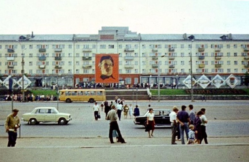 Дом напротив железнодорожного вокзала со встроенными магазинами «Золотой колос» и «Книги» на первом этаже и баннер с портретом С. М. Кирова. г. Киров. 1985 г.