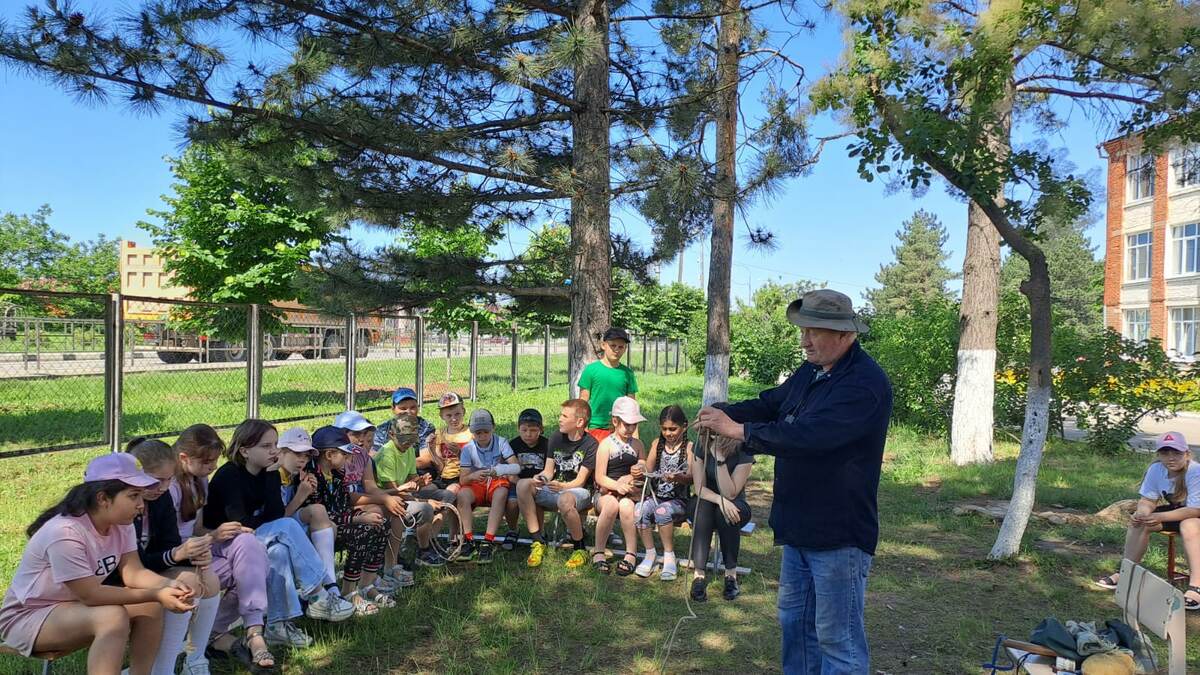 Александр Фёдорович Крутоголовенко рассказывает ученикам младших классов МБОУ СОШ №62, что должно быть в рюкзаке у каждого туриста и каким узлом можно воспользоваться в критической ситуации.