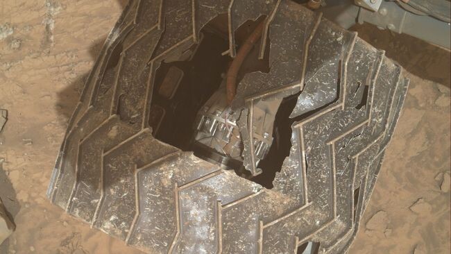     Повреждение правого среднего колеса марсохода Curiosity, обнажившее внутренние механизмы устройства.    
 Источник: NASA / MAHLI