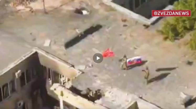    ТВ "Звезда" Российские военные с красным и государственными флагами на крыше здания при освобожденнии города Угледар в ДНР