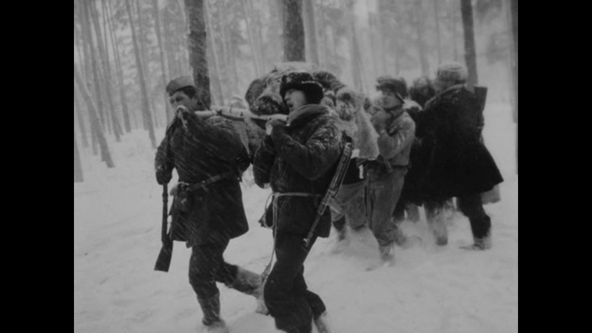 Партизаны несут раненного. Кадр из фильма