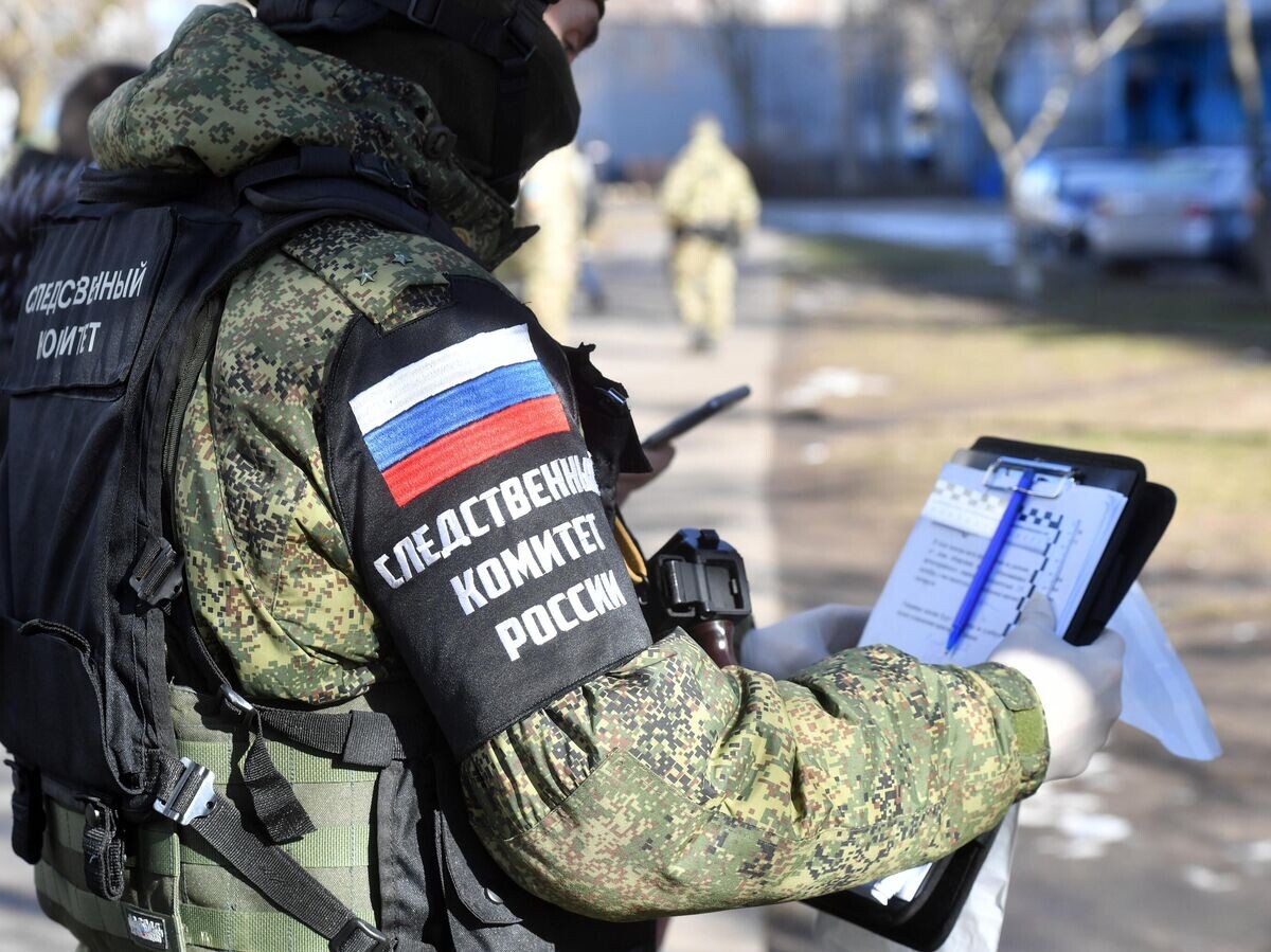    Сотрудник Следственного комитета РФ во дворе жилого дома в городе Энергодар Запорожской области© РИА Новости