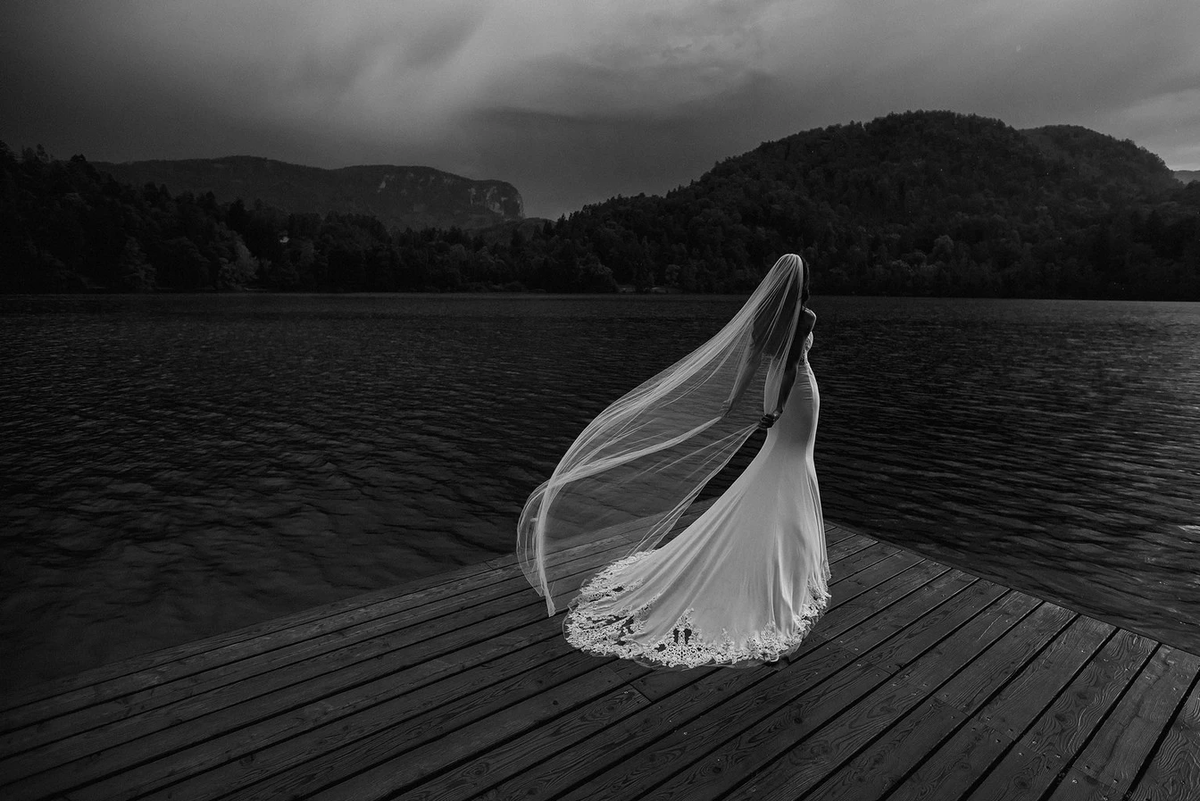 Этот свадебный портрет был сделан Аной Грегорич во время шторма на озере Блейско, популярном месте проведения бракосочетаний в Словении. "Обычно нам приходится подбрасывать фату в воздух, но на этот раз ветер справился на славу", - говорит Ана. Снимок сделан на камеру Canon EOS 5D Mark IV с объективом Canon EF 16-35 мм f/2.8L II USM (теперь его сменил объектив Canon EF 16-35 мм f/2.8L III USM) при разрешении 16 мм, 1/800 сек, f/2.8 и ISO 100. © Ана Грегорич
