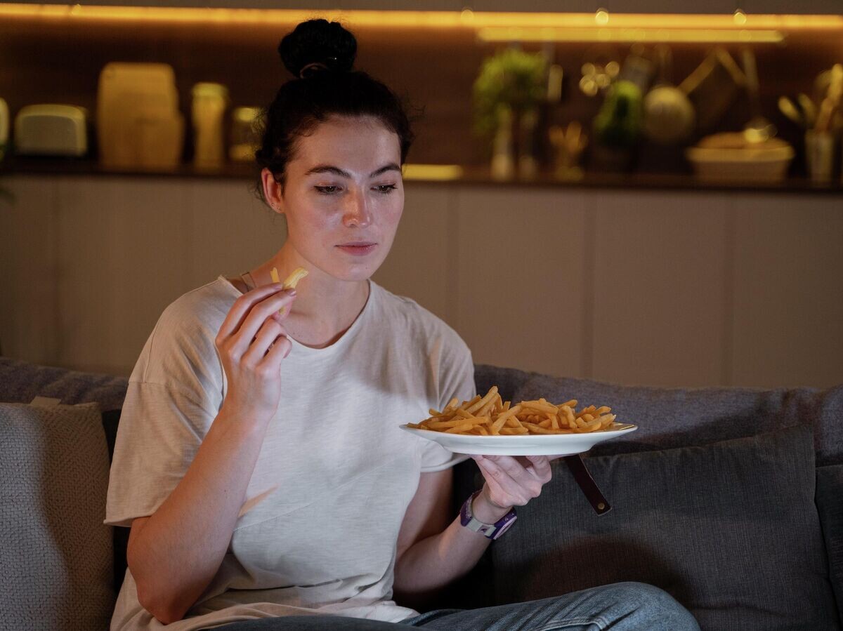    Женщина ест картошку фри© Фото : Freepik