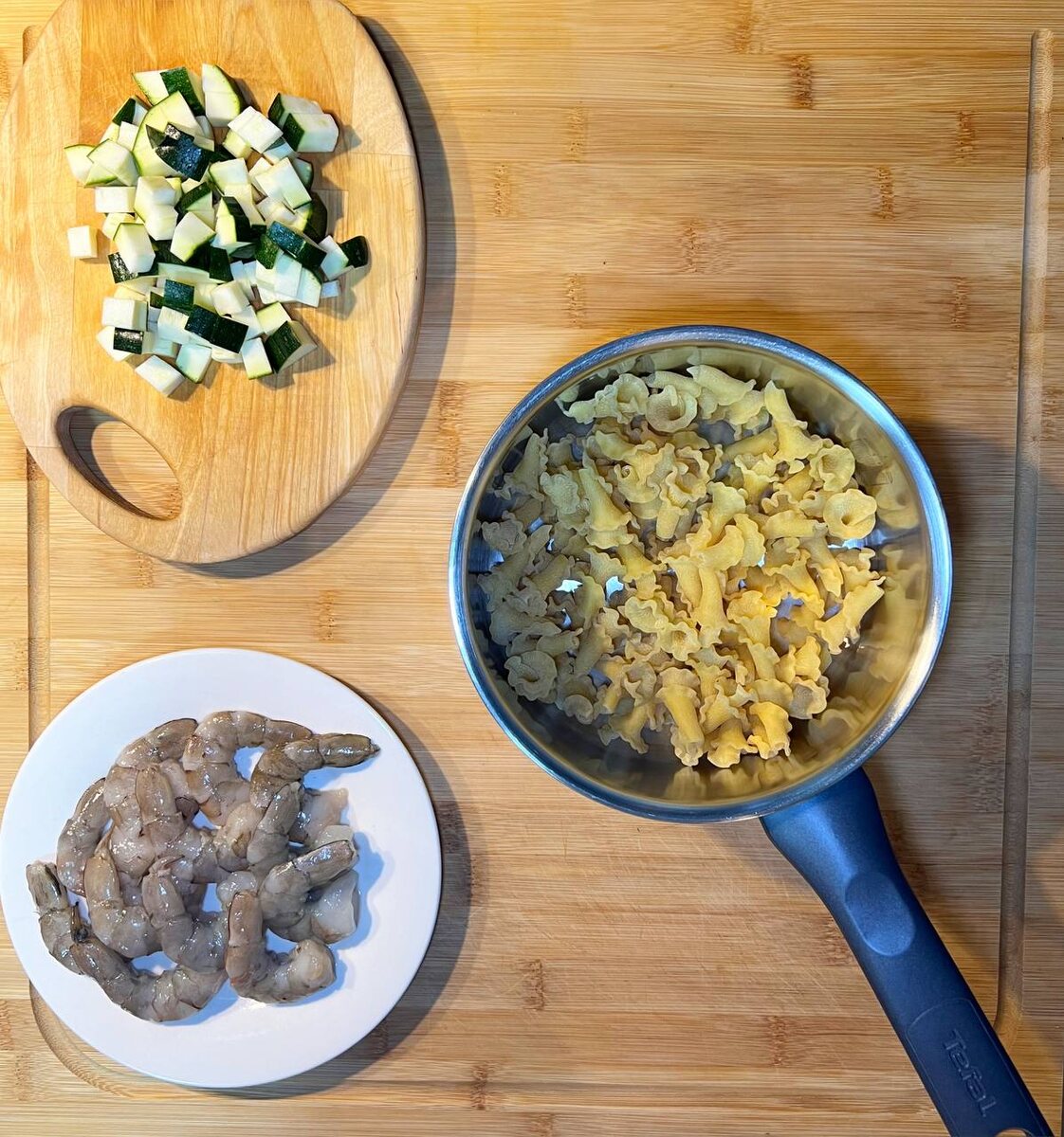 Отварите пасту в подсоленной воде до готовности.Очистите креветки и нарежьте цукини среднем кубиком.