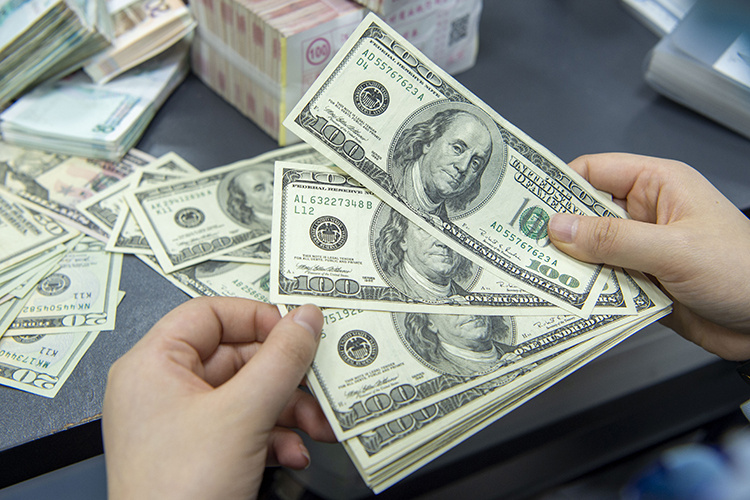    April 26, 2022, Haian, Jiangsu, China: HAIAN, CHINA - APRIL 26, 2022 - A staff member counts US dollar notes at a bank in Haian, East China s Jiangsu province, April 26, 2022. The People s Bank of China (PBOC), the central bank, decided on Thursday to cut the foreign exchange reserve ratio (RRR) for financial institutions by 1 percentage point from the current 9 percent to 8 percent starting May 15, 2022, in a bid to improve their ability to use foreign exchange funds. (Credit Image: Global Look Press/Keystone Press Agency) Ani