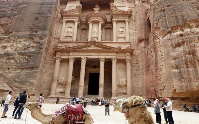 На снимке, сделанном 25 марта 2015 года, изображены туристы, прогуливающиеся перед Хазне (Сокровищницей) в древнем городе Петра в Иордании. (Фото Халила МАЗРААВИ / AFP)