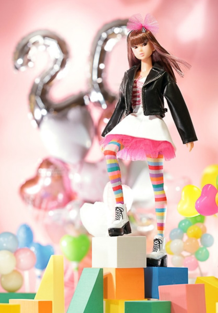 «Год за годом она добавляет разных красок, и вот теперь их 20-ть! Это двадцатый юбилей куклы Момоко. Она остается идолом своего времени!» (фрагмент описания выпуска с сайта Секигучи)