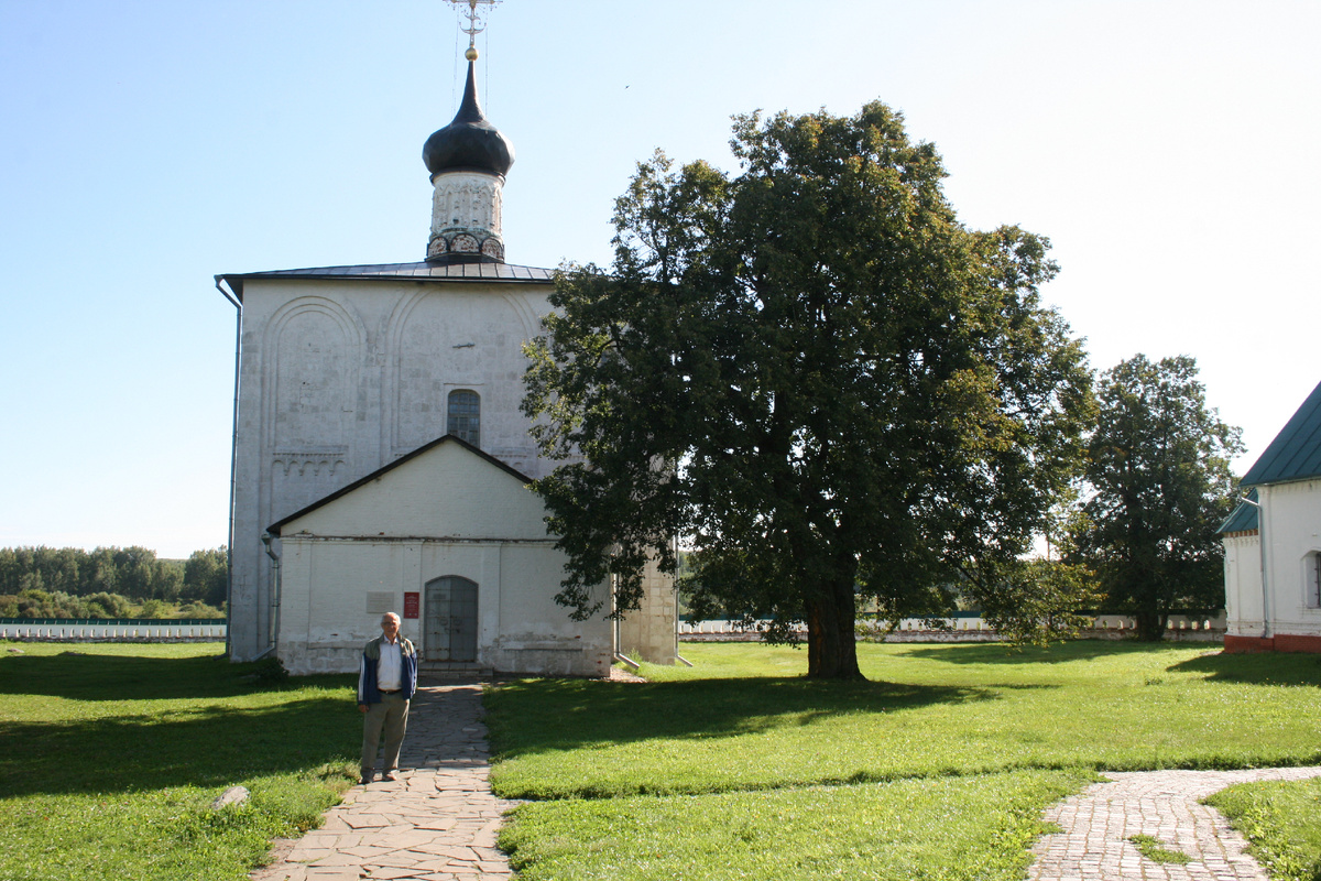 Я стою на фоне здания церкви Бориса и Глеба в Кидекше. Западный фасад.