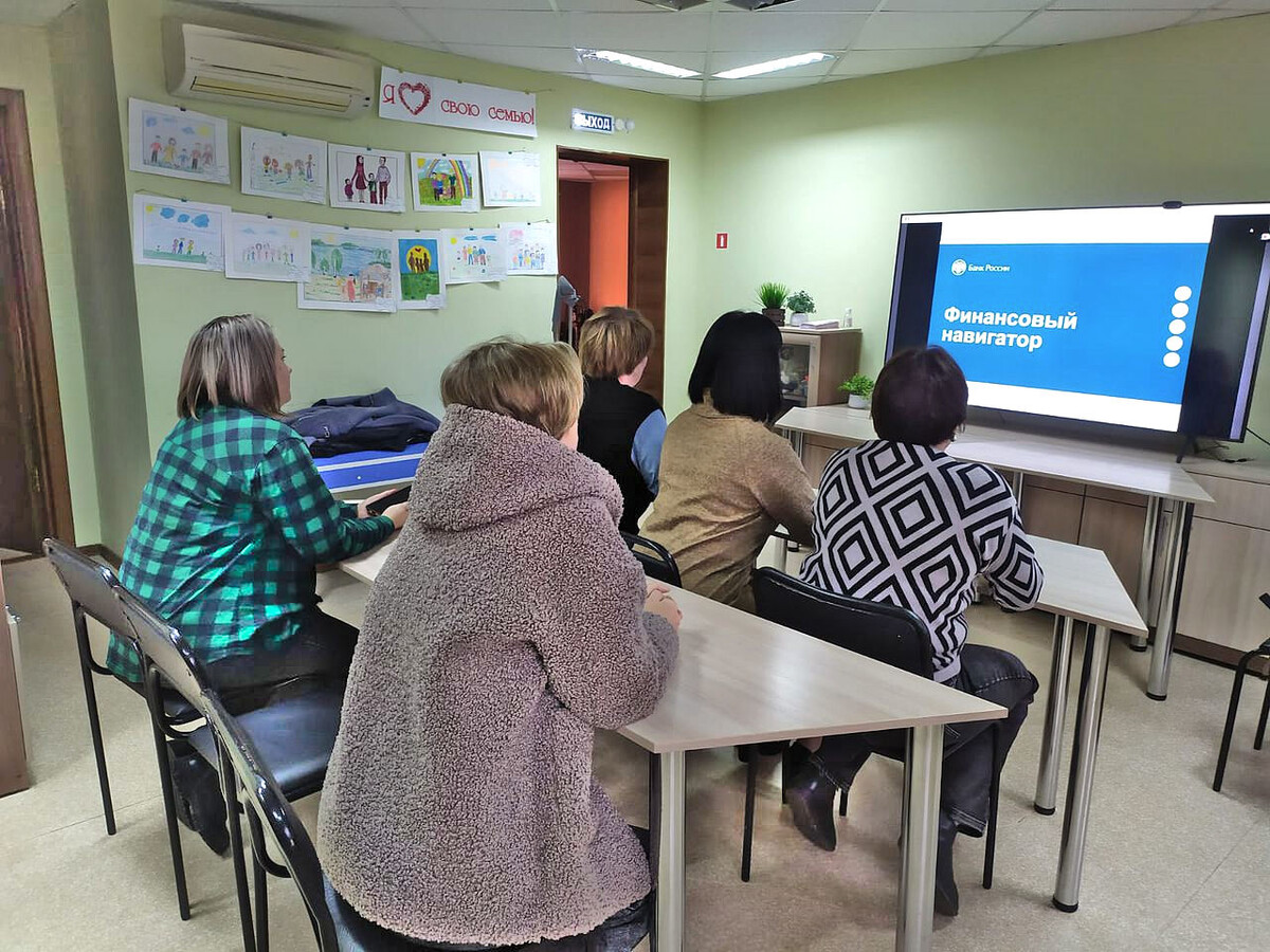 Слушатели смотрят на презентацию на большом экране