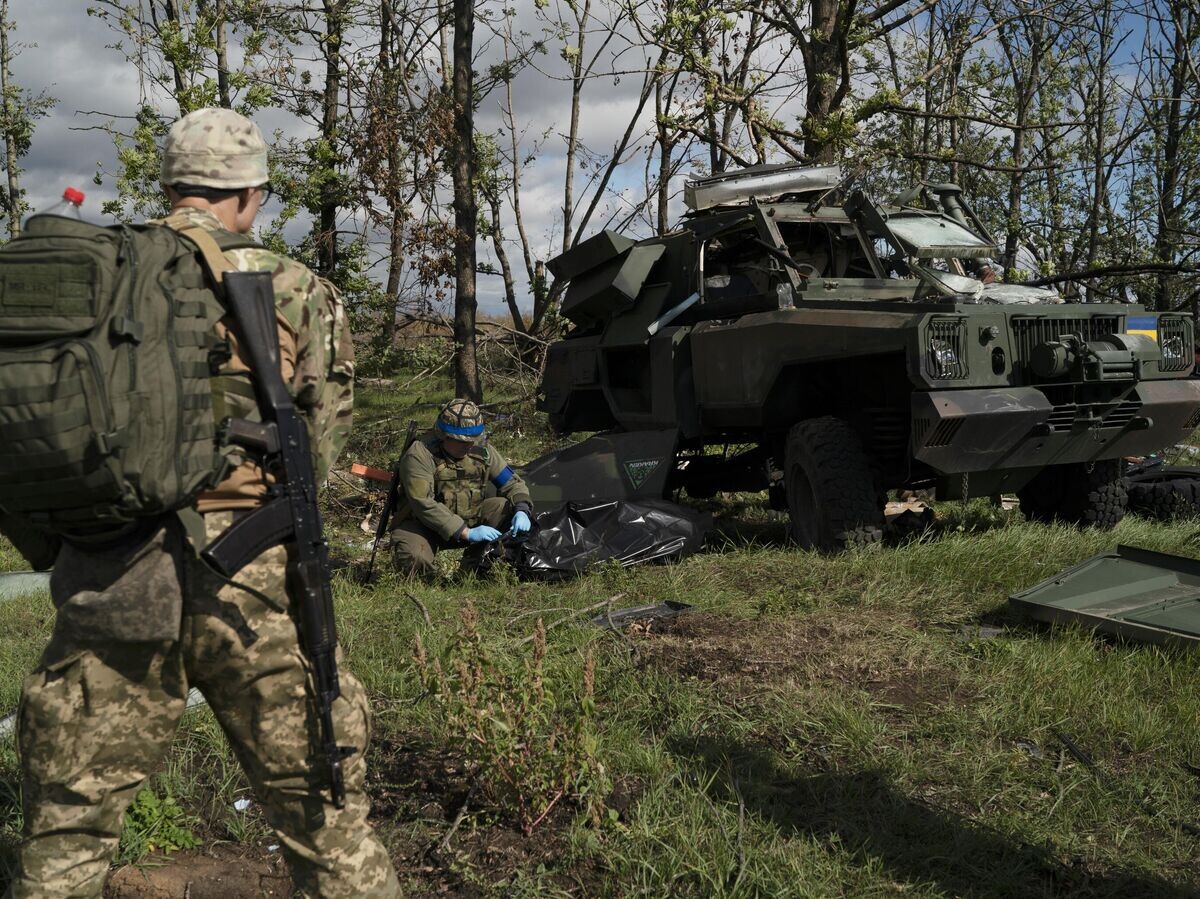    Украинские военнослужащие рядом с уничтоженным бронетранспортером ВСУ в Харьковской области© AP Photo / Leo Correa