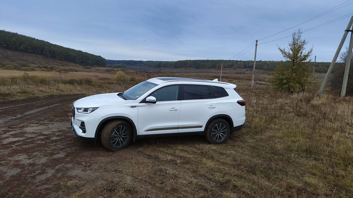 Белый кроссовер Chery на фоне размытой дороги выглядит очень красиво